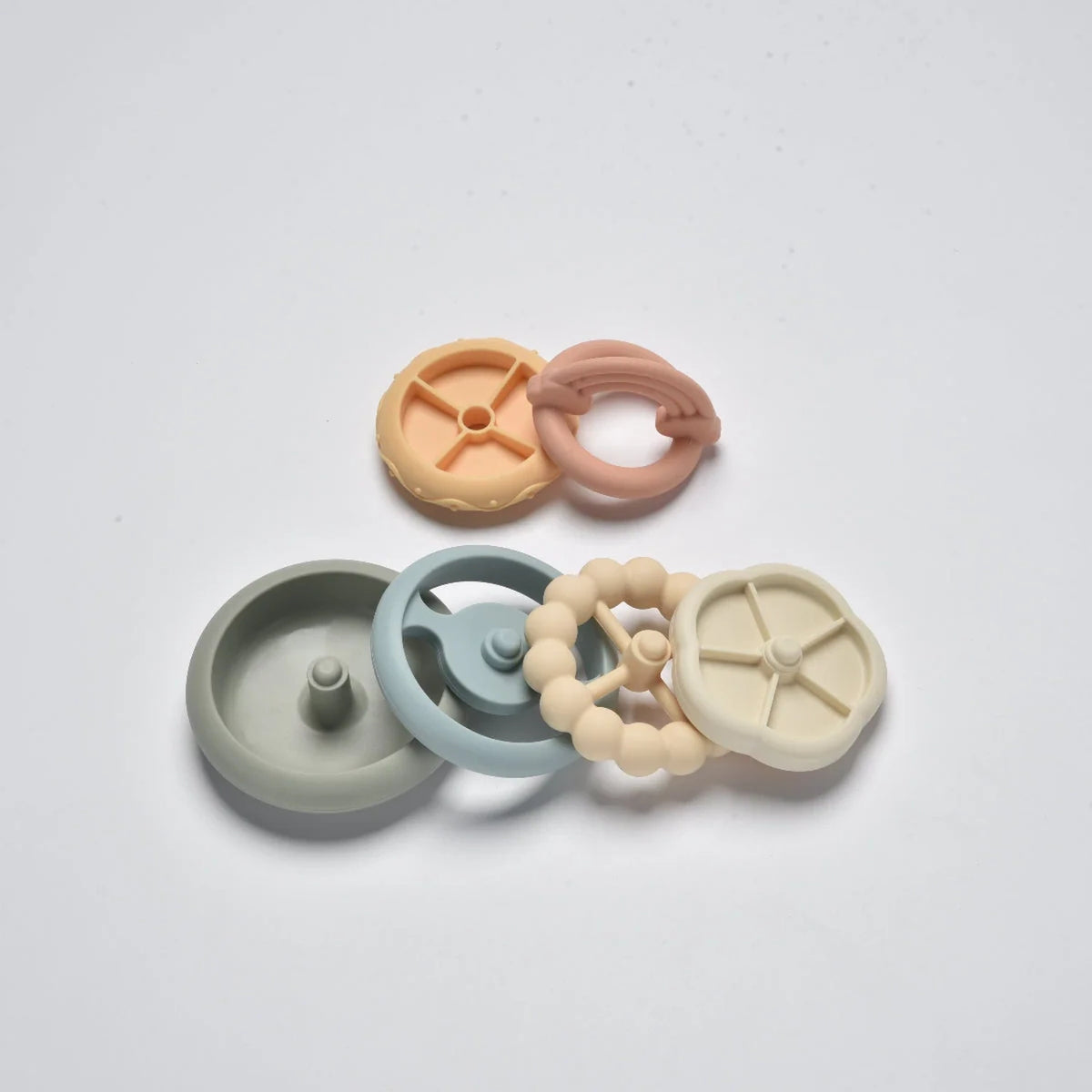 Pastel silicone rainbow stacking tower pieces laid unstacked in a flat lay view.