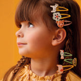 Girl wearing Colomba jungle collection parrot and leaf hair clips with mixed jungle animal snap clips in braided hair.