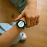 Close-up of a person's wrist wearing a Kidywolf smartwatch with a colorful logo on the screen.