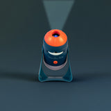 Moulin Roty Les Explorateurs space projector toy projecting light beam upward in navy blue and orange rocket design.