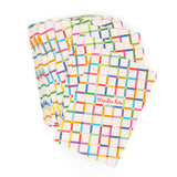 A fan of colorful, grid-patterned Moulin Roty playing cards with vibrant blue, yellow, pink, and green lines.