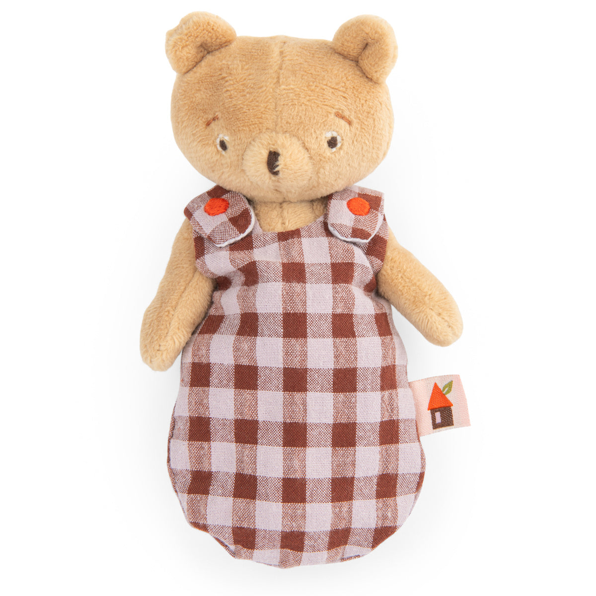A plush teddy bear wearing a brown and white checkered dress with orange button details. The bear, with a gentle expression, has a small fabric tag on the side.