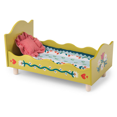 Les Minouchkas toy wooden doll bed in mustard yellow with floral details and a striped pillow.