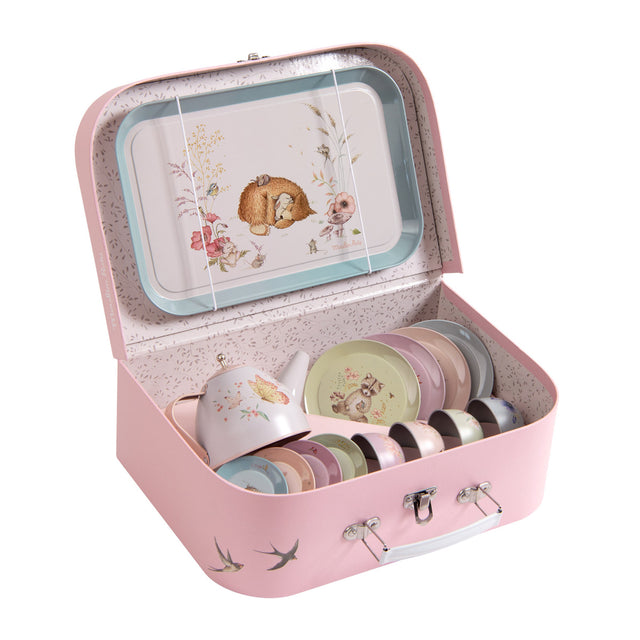 A pink suitcase with bird designs contains a children's tea set, including pastel cups, plates, and a teapot. A tray featuring a hedgehog is displayed inside.