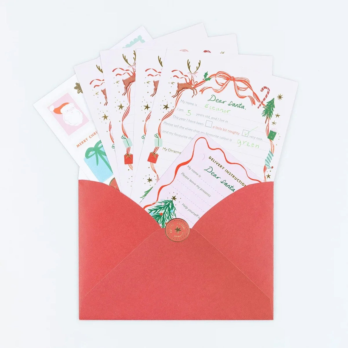 Red envelope with Christmas letter-to-Santa templates and delivery instruction cards inside.