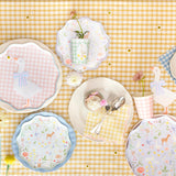 Flat lay of a picnic table setting with goose and woodland-themed paper plates, cups, and a cupcake.