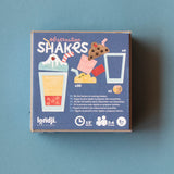 Londji Shakes observation board game box featuring colorful milkshake illustrations and gameplay details on a blue background.