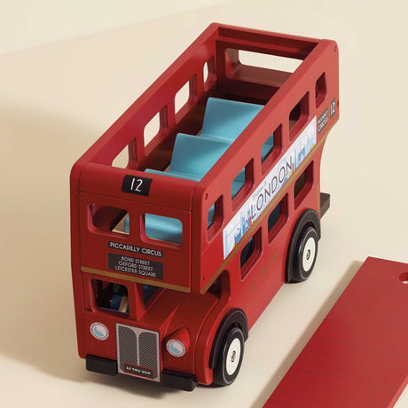 Classic red double-decker London bus wooden toy with blue seats and removable roof section.