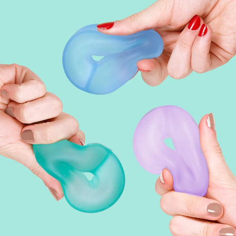 Three hands squeezing squishy, cool-toned ring-shaped memory gel stress toys.
