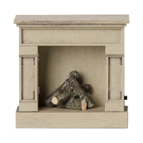 Miniature off-white dollhouse fireplace with tiny logs inside on a white background.