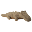 A soft, brown stuffed animal shaped like a crocodile lies against a white background. It has small eyes and a friendly, relaxed appearance.