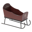 Brown wooden sled with decorative white patterns on the sides, set on black metal runners against a white background. It has a rustic, vintage feel.