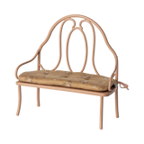 Vintage-style miniature wrought iron bench with a light brown, floral-patterned cushion. The elegant curves of the metal frame add a classic charm.