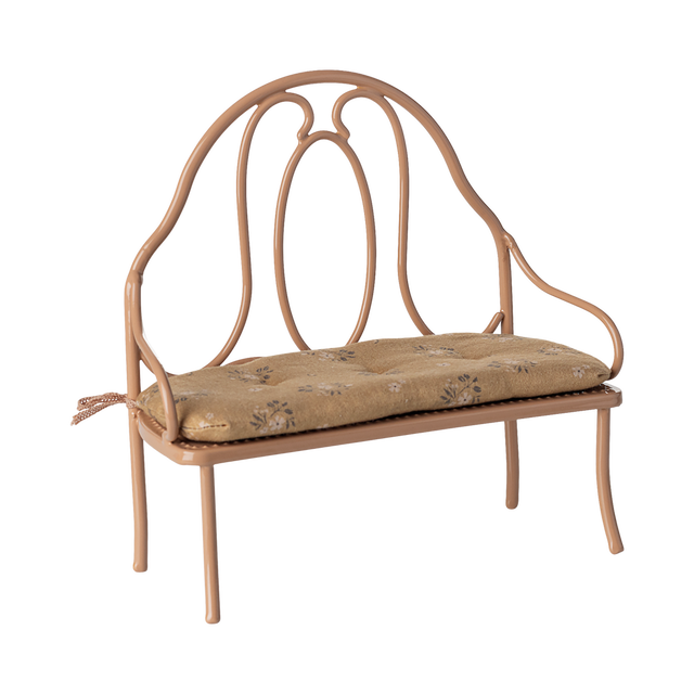 Vintage-style miniature wrought iron bench with a light brown, floral-patterned cushion. The elegant curves of the metal frame add a classic charm.