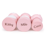 Bottoms of three pink toy cat figures printed with the names Kitty, Milo, and Coco.
