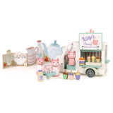 Wooden toy milkshake van with cat figures set against a printed kitchen backdrop.