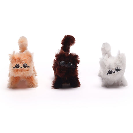 Three miniature fuzzy pipe cleaner animals in beige, dark brown, and white on a plain background.