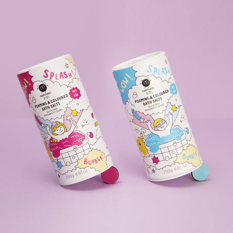 Two playful bath salt containers on a pink surface, featuring colorful illustrations of children and bubbles, conveying fun and excitement.