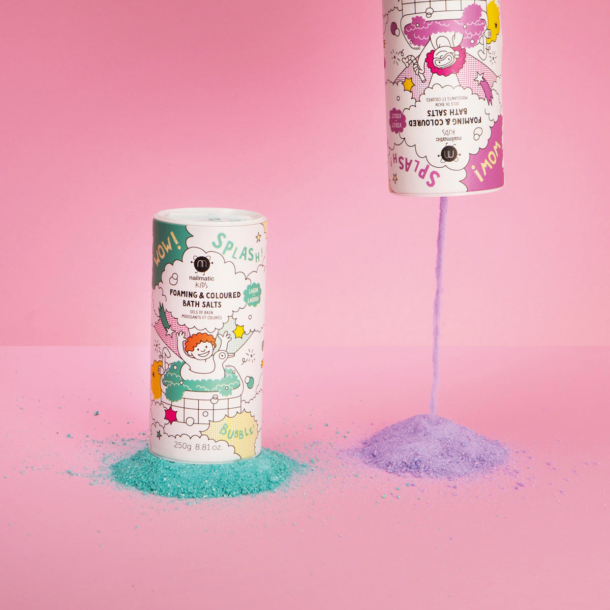 Two colorful bath salt containers on a pink background. One upright with green salts, the other pouring purple salts, creating playful mounds.