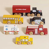 Set of six wooden toy city vehicles neatly arranged on a neutral beige background.