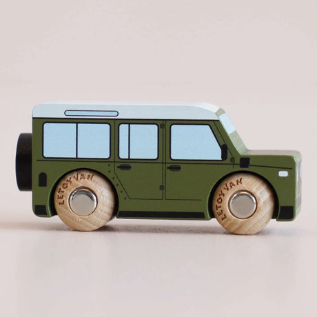 Side profile of a green wooden toy car with a white roof and natural wood wheels.