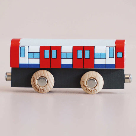 Side profile of a red, white, and blue wooden toy train carriage on a light background.