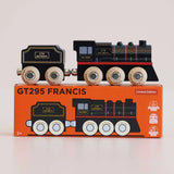 Black wooden toy steam train with natural wood wheels, resting on its orange packaging box labeled GT295 FRANCIS.
