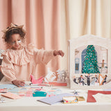 Young girl setting up a mini Nutcracker paper theater with various props and cutouts.