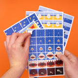 Hands peeling a sticker from a sheet of ocean-themed animation stickers on an orange background.