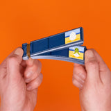 Hands holding an ocean-themed flip book against a bright orange background, showing a sea turtle hatching.