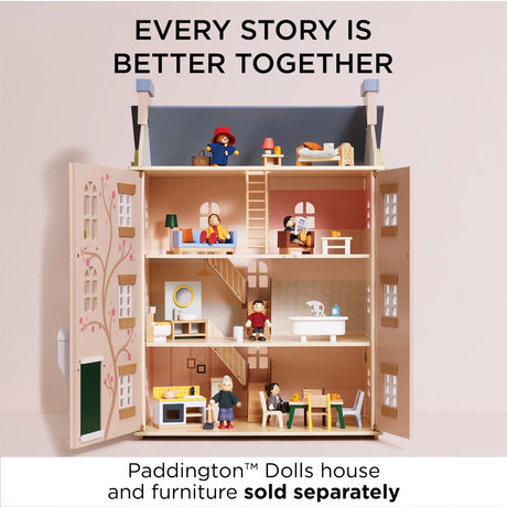 Wooden Paddington Bear figure and family dolls placed throughout the rooms of an open three-story dollhouse.