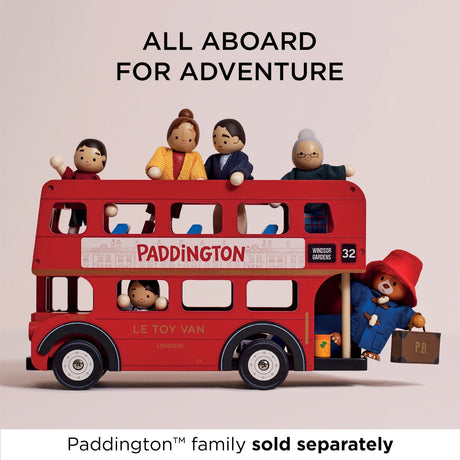 Red wooden toy London bus carrying wooden people figures, with Paddington Bear getting on at the rear.