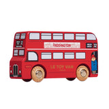A red wooden toy London double-decker bus featuring Paddington Bear branding and wooden wheels.