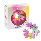 Puzzle toy "Hexel" in pastel bubblegum colors is arranged in a circular shape. The packaging has a gradient design and displays the motto "Flex. Fidget. Play."