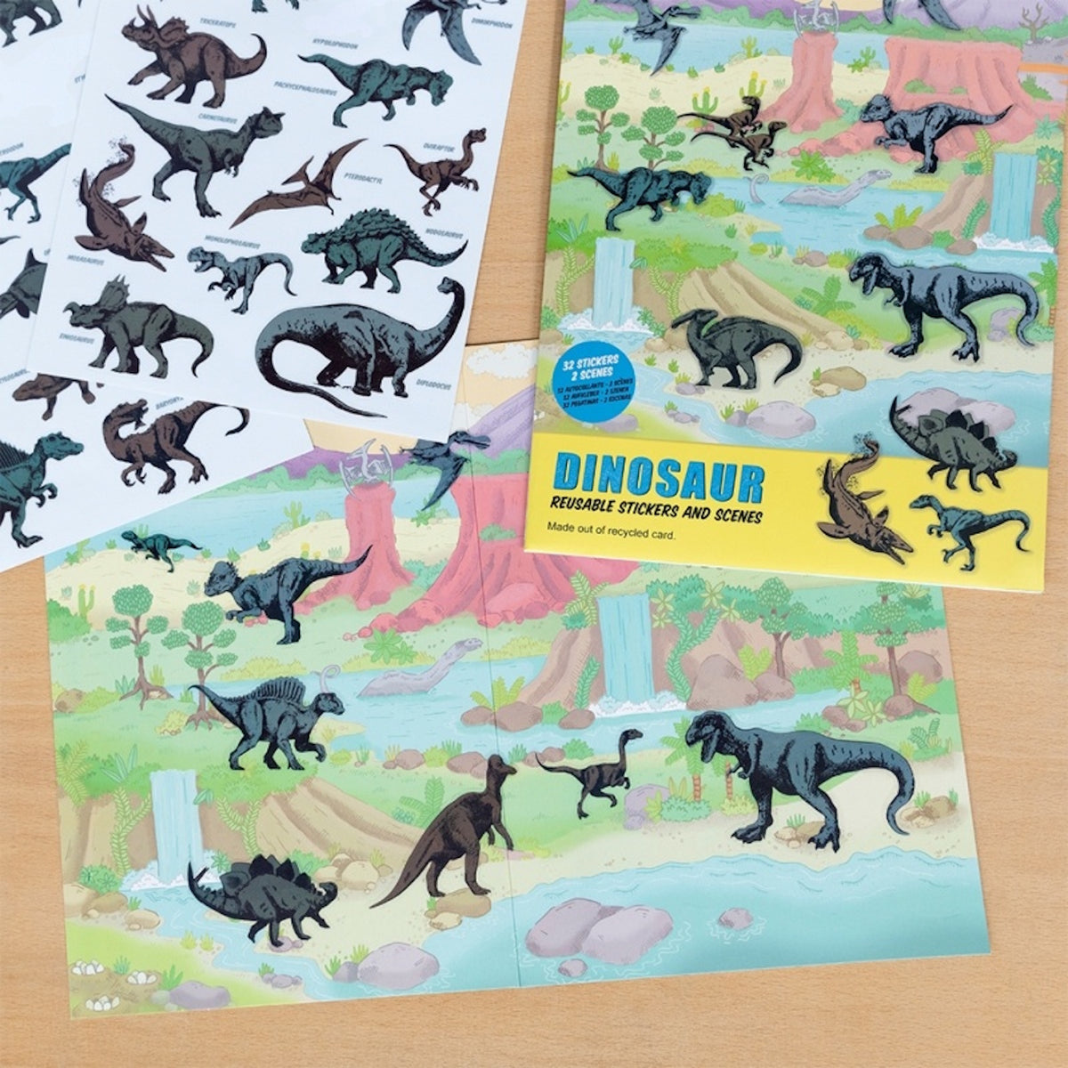 Dinosaur reusable sticker set open on a wooden table showing interactive prehistoric scene sheets.