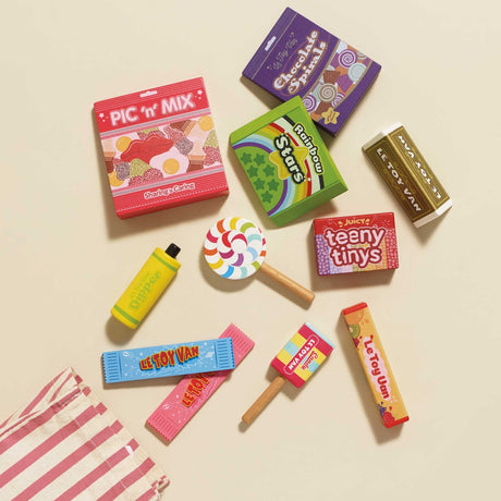 Top-down view of colorful wooden play candy and sweet boxes spread out on a plain surface.