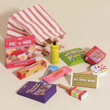 Wooden toy sweet set with boxes, lollipops, and a pink striped fabric bag scattered on a surface.