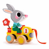 Wooden bunny pull toy riding a yellow car with a flower, perfect for toddler developmental play.