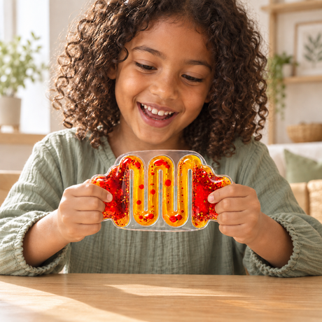 Front view of a child playing with a red-and-yellow liquid-filled sensory squeeze toy.
