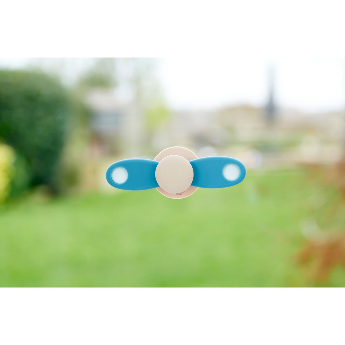 A soft silicone toy featuring a propeller design in neutral tones, ideal for sensory exploration and fine motor skill development.