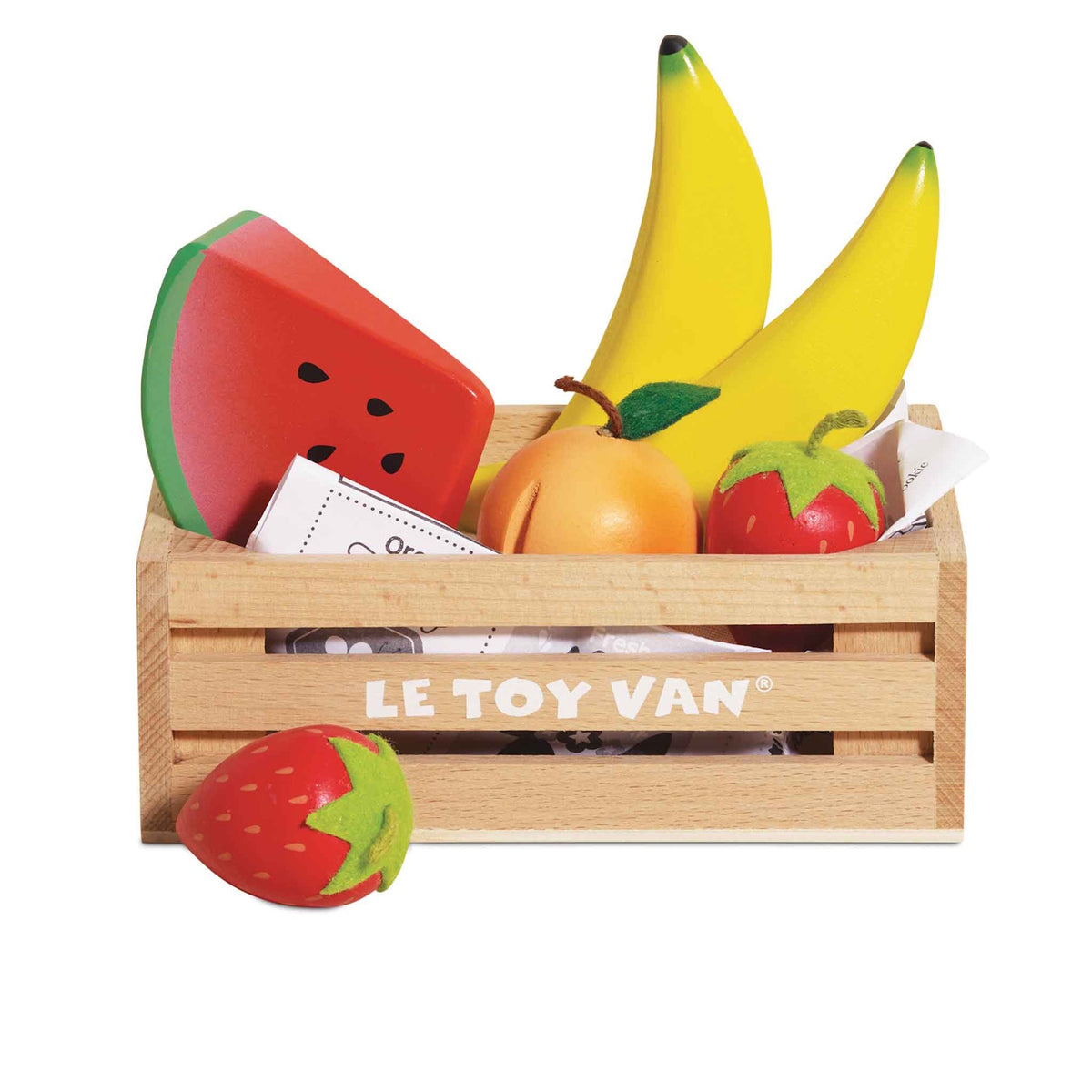 Wooden toy fruit set in a Le Toy Van crate with a strawberry sitting in front.