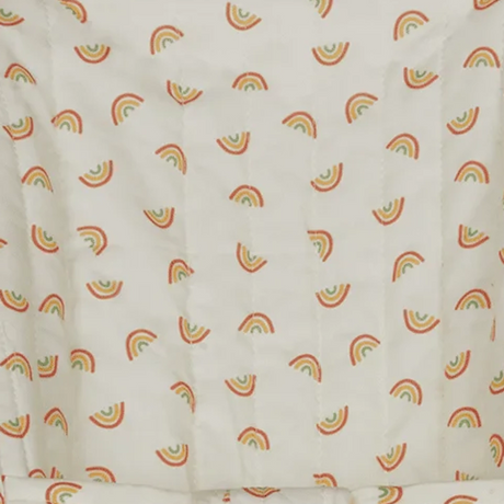 Close-up of off-white quilted fabric featuring a seamless pattern of colorful mini rainbows.