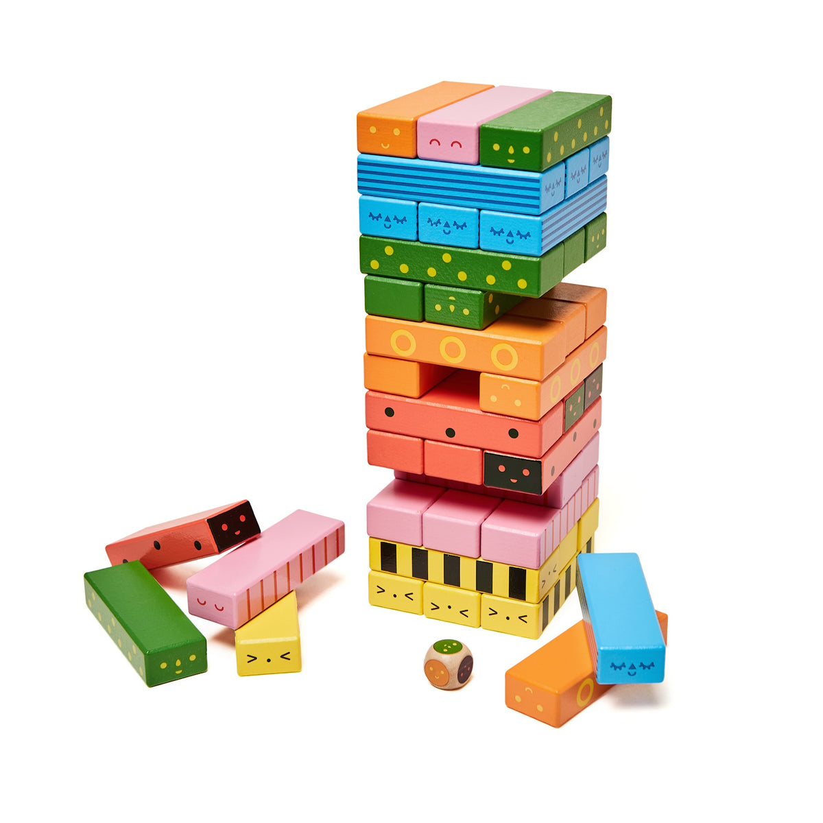 Colorful wooden balance game tower with cute face patterns, loose blocks, and a wooden die on a white background.
