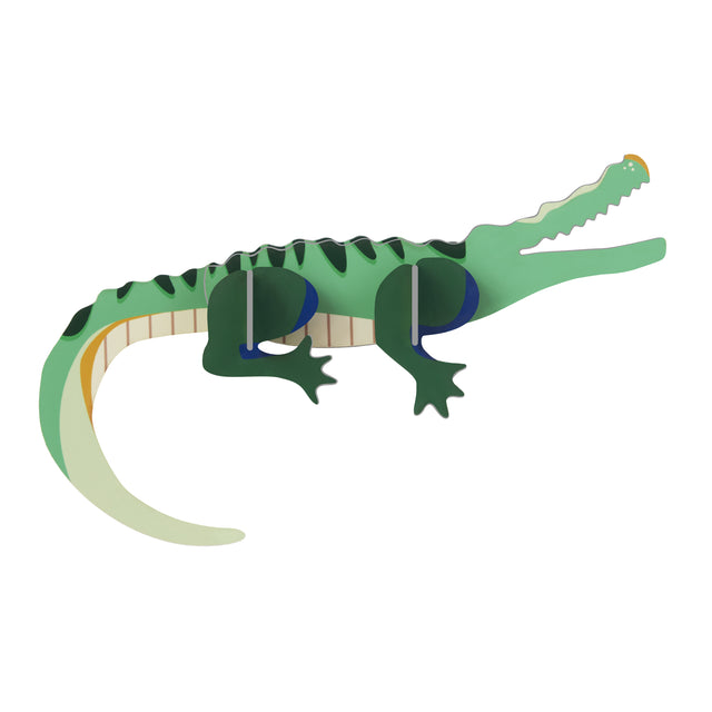 3D puzzle of a green crocodile with layered segments. It's cartoonish and playful, with a long tail and open mouth, against a plain white background.