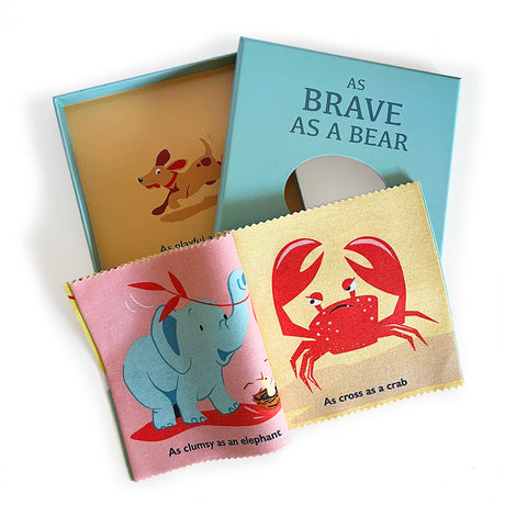 "As Brave As A Bear" cloth rag book with illustrated elephant and crab pages next to its gift box.