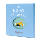 Light blue gift box for "The Noisy Farmyard" book with a chick hatching illustration in a circular window.