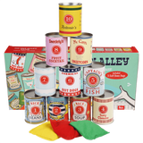 Stacked vintage game tin cans and colored bean bags positioned in front of their product box.