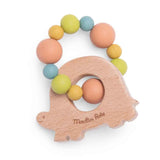 Reverse side of a wooden turtle teether with "Moulin Roty" engraved, featuring a colorful silicone bead ring.