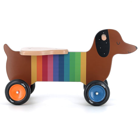 Vilac rainbow dachshund wooden ride-on toy for toddlers with colorful wheels and easy-grip handles on a white background.