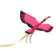 Pink flamingo kite flying with outstretched wings, featuring black tipped feathers and a long yellow tail.